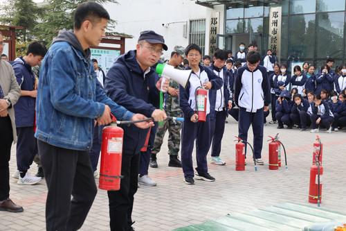 2.副校长王宏亮对干粉灭火器的正确使用方法进行讲解和示范 2.副校长王宏亮对干粉灭火器的正确使用方法进行讲解和示范
