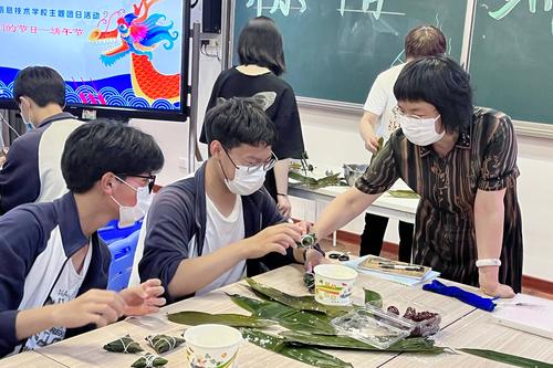 5.校长韦艳春与学生一起研究粽子的包法(1) 5.校长韦艳春与学生一起研究粽子的包法(1)