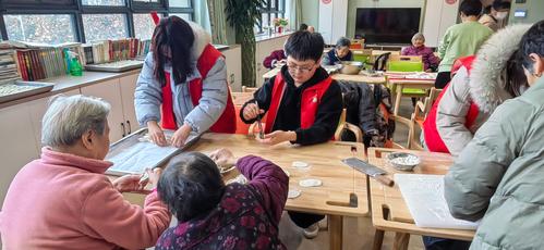 学生张佳源在老年服务中心与老人们一起包饺子 学生张佳源在老年服务中心与老人们一起包饺子