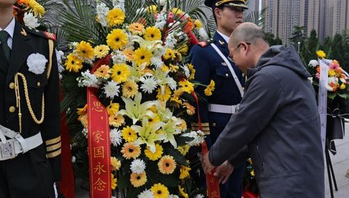 王宏亮整理花篮绶带。蔡科研 摄