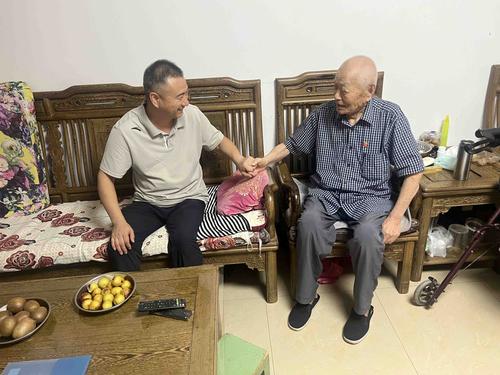 副校长赵志强与老党员庞振邦亲切交谈